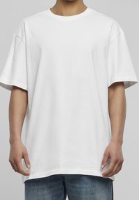 Bílý oversized tričko s krátkým rukávem, kulatým výstřihem a měkkou bavlněnou tkaninou. Jednoduchý design bez viditelných vzorů nebo akcentů.