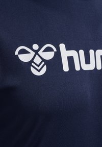 Navyblauwe stof met een wit logo met een bijontwerp, inclusief ronde vleugels en een geometrisch lichaam. Gladde textuur.