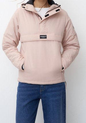 Veste à capuche rose clair avec des accents noirs, poche frontale, détails en zipper et un patch logo sur la poitrine.