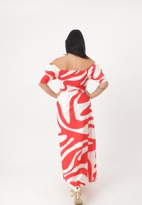 Maxikleid mit einem rot-weißen abstrakten Muster, schulterfreiem Design, gerafftem Oberteil und lockerer Passform mit kurzen Puffärmeln.