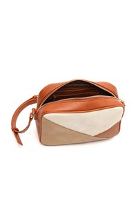 Kožená crossbody taška s uzávěrem na zip, barevným blokováním v oranžové a béžové barvě, geometrickým designem a odnímatelným popruhem.