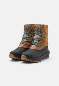 Ruskeat vedenpitävät saappaat, joissa on siniset nauhat, mokkanahkainen päällinen, kumipohja ja pyöristetty kärki; sivuilla on kuvioidut yksityiskohdat ja pohjassa pito. 