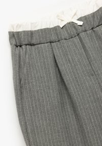 Grå stribede bukser med en blød, elastisk talje og en cremefarvet snor. Subtil tekstur og skræddersyede folder i stoffet.