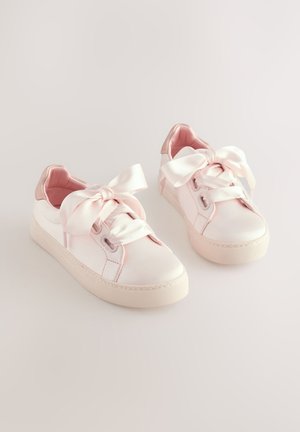 Roze satijnen sneakers met een gladde afwerking, grote strikveters, een gestructureerde rubberen zool en een contrasterend roze hielaccent.