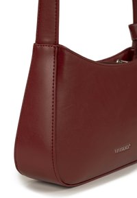 Dunkelrote Leder-Umhängetasche mit glatter Oberfläche, silbernem Reißverschluss und kleinem silbernem „VIVISENCE“-Logo unten rechts.