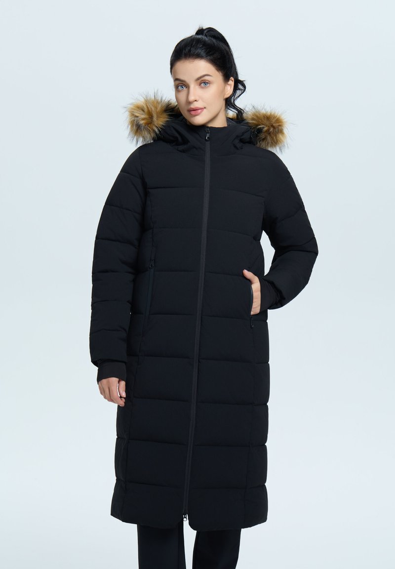 Schwarze Steppjacke mit Kapuze, die einen Kunstfellbesatz hat, gesteppter Optik, langer Länge und Seitentaschen. Reißverschluss vorne.