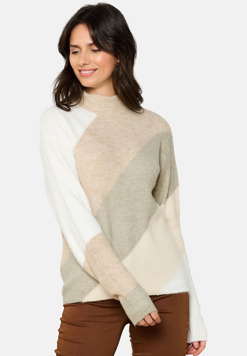 Maglione oversize beige e bianco con colletto alto, caratterizzato da motivi a blocchi di colore diagonali e texture a coste sulle maniche e sull'orlo.