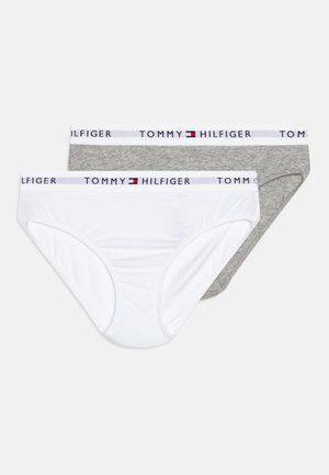 Dva para bombažnih hlačic, ena bela in ena siva, vsaka z blagovno znamko na pasu, ki prikazuje "TOMMY HILFIGER."