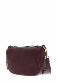 Petit sac à main en cuir violet foncé avec des accessoires en or et une sangle détachable sur un fond blanc.