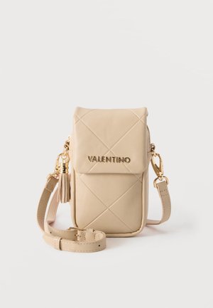 Sac bandoulière matelassé beige Valentino avec rabat, logo doré, détail pompon et bandoulière ajustable sur fond blanc.