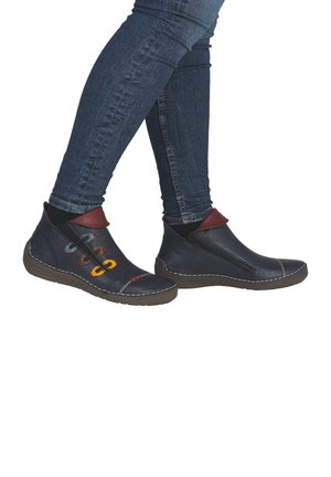 Bottines en cuir bleu marine avec fermeture éclair, col contrastant rouge et œillets décoratifs multicolores avec des accents de couture.