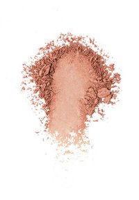 Blush in polvere sfusa di un caldo tono pesche, con una texture morbida, distribuito attorno a un'area centrale liscia, creando un effetto gradiente naturale.