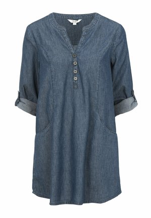 Tummansinisestä denim-tunikapuserosta, jossa on V-pääntie, kolme nappia edessä, käärityt hihat ja kaksi sivutaskua. Pehmeä materiaali.