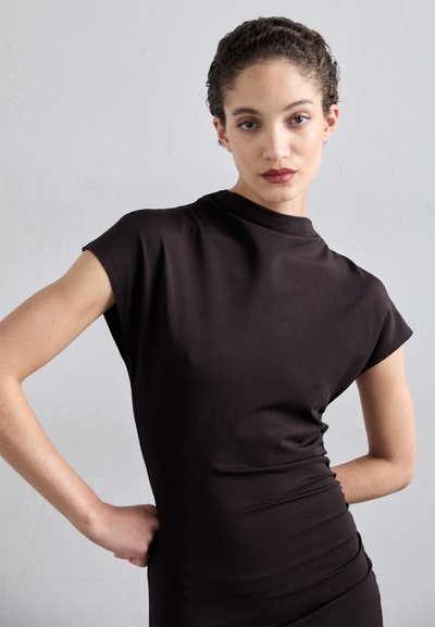 Rochie scurtă neagră cu mâneci scurte, gât înalt, design ajustat și textură fină. Prezintă cute subtile pe o parte.