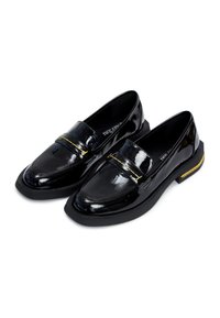 Mocassins en cuir verni noir avec une finition lisse, dotés d'un accent doré sur le coup de pied et d'une épaisse semelle noire.