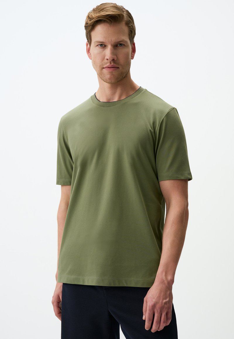 Oliwkowa koszulka z krótkim rękawem z miękkiego materiału, okrągły dekolt, z prostym wzorem bez widocznych motywów ani ozdób.