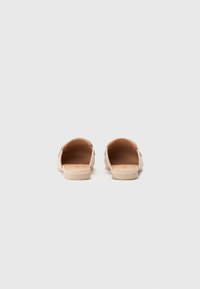 Beige Slipper mit flacher Sohle, offenen Fersen und glatter Ledertextur. Einfaches Design ohne Verzierungen oder Muster.