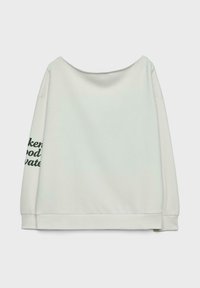 Felpa oversize grigia chiara con scollatura a barca, maniche lunghe e testo verde sulla manica sinistra. Materiale morbido con una vestibilità rilassata.