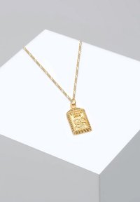 Goldene Halskette mit einem Anhänger, der ein graviertes Design mit dem Wort "VENUS" und komplizierten Mustern zeigt, aufgehängt an einer zarten Kette.