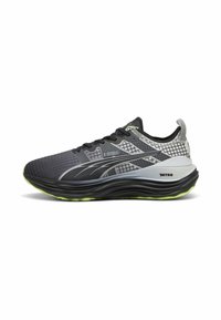 Scarpe da ginnastica nere e grigie con una tomaia in rete testurizzata, dettagli riflettenti e una suola verde. Design leggero con un'intermedia ammortizzata.