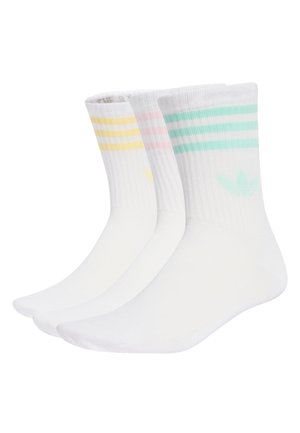 Tres pares de calcetines blancos de caña corta con puños acanalados, cada uno con tres franjas horizontales y un logo de trébol en amarillo, rosa y verde.