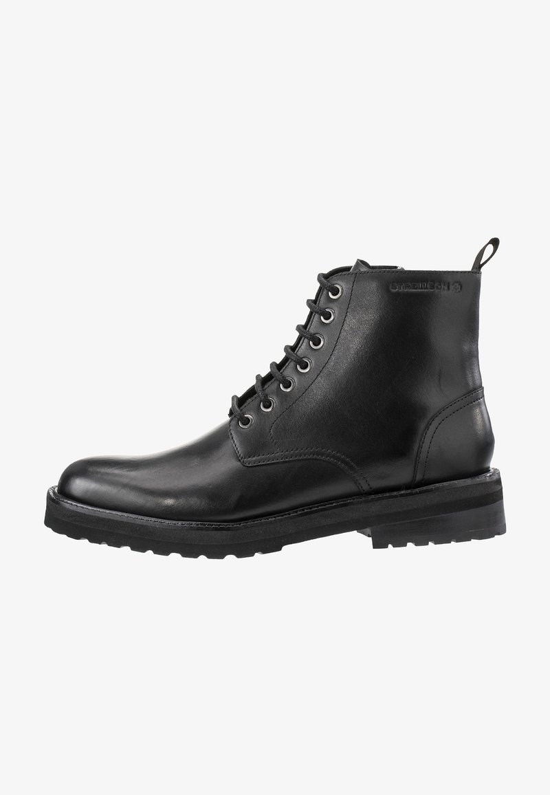 Bottes basses en cuir noir à finition lisse, bout rond, huit œillets pour les lacets et semelle en caoutchouc robuste. Dotées d'une languette arrière pour les enfiler.