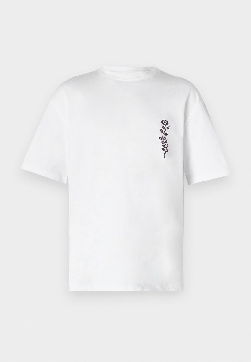 Witte katoen T-shirt met korte mouwen en een ronde hals. Heeft een klein zwart bloemenmotief op de linkerkant van de borst.