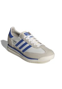 Sneaker Adidas SL72 v šedé a modré barvě, vyrobený z kůže a syntetických materiálů. Obsahuje tři modré pruhy a bílé tkaničky na texturované podrážce.