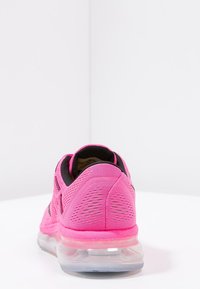 Baskets de sport roses avec une tige en maille texturée, intérieur noir et semelle transparente. Dotées d'un col rembourré et d'un branding minimal.