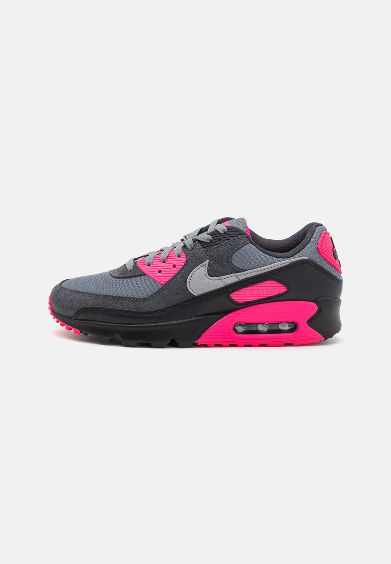 Nike Air Max-sneaker har en grå mesh-overdel med svarte semskede detaljer, rosa høydepunkter og en synlig luftpute i sålen.