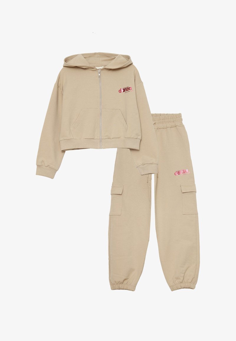 Completo jogger beige composto da una felpa con zip e design crop e un paio di pantaloni affusolati con due tasche laterali. Dettagli logo rosa.