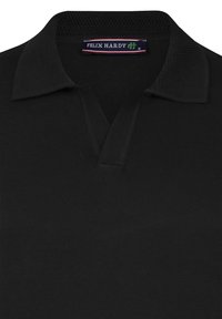 Camiseta de polo negra con un cuello texturizado y un escote en V, confeccionada en una tela suave y ligera. Etiqueta de la marca visible en el interior del cuello.
