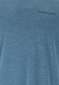 Sininen urheilupaita, joka on valmistettu teksturoidusta kankaasta. Sisältää hienovaraisen heather-kuvion ja mustalla painetun sanan "KESTÄVYYS".