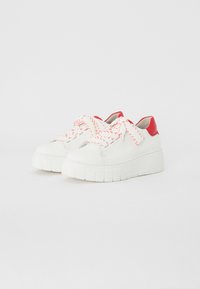Baskets en cuir blanc avec une semelle épaisse et striée, et des accents rouges. Présentent des lacets à motifs rouge et blanc, un bout arrondi et un talon rembourré.