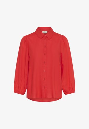 Rote Bluse mit langen Ärmeln, durchgehender Knopfleiste, abgerundeten Manschetten, leicht aufgeplusterten Schultern und klassischem spitzem Kragen.