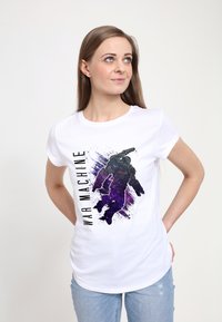 Bílý bavlněný tričko s grafikou fialové a černé postavy v brnění a textem "WAR MACHINE" tučně psaným černým písmem.