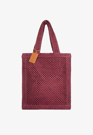 Borsa tote color mogano lavorata all'uncinetto con due manici e un'etichetta rettangolare in pelle marrone chiaro attaccata vicino a un manico.