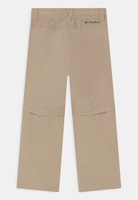 Béžové lehké kalhoty s elastickým pasem, plochými švy a zipovým horním dílem pro přeměnu na šortky. Logo značky na zadní straně.