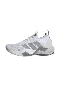 Hvid atletiksko med netoverdel, grå accenter, tekstureret sål og en støttende hælkappe. Har metalliske detaljer og åndbart stof.