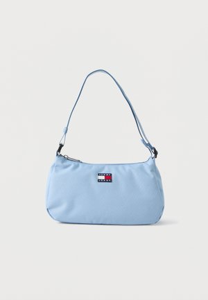 Jasnoniebieska torba na ramię Tommy Jeans z regulowanym paskiem i zamknięciem na zamek błyskawiczny na jednolitym tle.