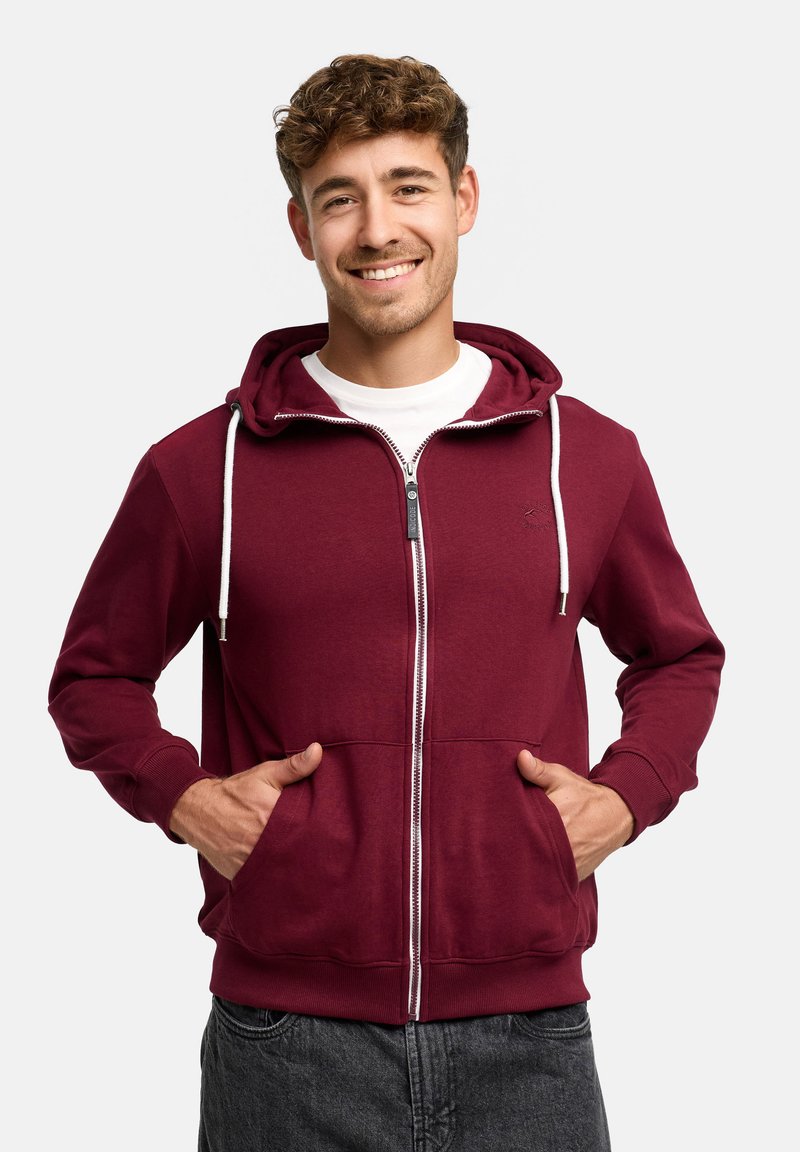 Burgundy zip-up hoodie with a drawstring hood, white zipper, and two front pockets. Made of soft fabric with ribbed cuffs and hem.