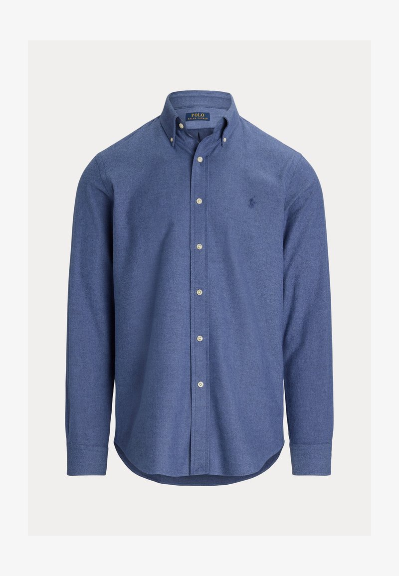 Blå skjorta med knäppning, tillverkad av texturerat tyg, med spetsig krage, långa ärmar och en liten logotyp på vänster bröst.