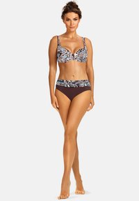 Zestaw bikini z kolorowym wzorzystym topem i jednolitymi brązowymi majtkami. Posiada regulowane ramiączka oraz ozdobny pasek wzdłuż talii.