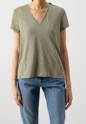 Olivegrünes T-Shirt mit kurzen Ärmeln und V-Ausschnitt, das mit einem strukturierten Muster aus kleinen, hellen Punkten versehen ist. Lässige Passform und weicher Stoff.