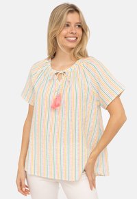 Top a righe con strisce verticali multicolori in tonalità pastello, scollatura rotonda con dettaglio a fiocco e un'accademia di frange rosa. Maniche corte.