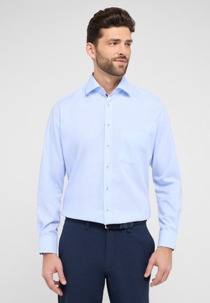 Light blue long-sleeve dress shirt with a button-down collar, one chest pocket, and silver buttons, paired with dark navy trousers.