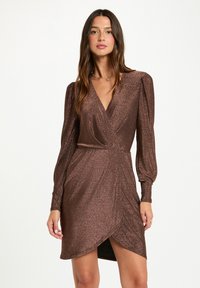 Vestito avvolgente marrone realizzato in un tessuto metallico testurizzato. Presenta maniche lunghe a sbuffo, una scollatura a V profonda e uno spacco laterale.