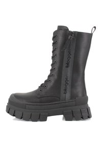 Bota negra de cordones hasta la rodilla, hecha de material sintético suave, con suela gruesa y estriada, y un detalle de cremallera con logotipo.