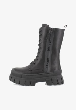 Bota negra de cordones hasta la rodilla, hecha de material sintético suave, con suela gruesa y estriada, y un detalle de cremallera con logotipo.