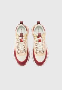 Lace-up sneakers featuring a cream mesh upper, maroon accents, gold detailing, and a textured sole. Notable brand logo on the tongue.